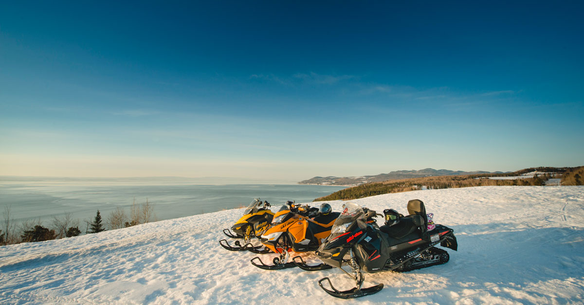 Snowmobiles in front of the river